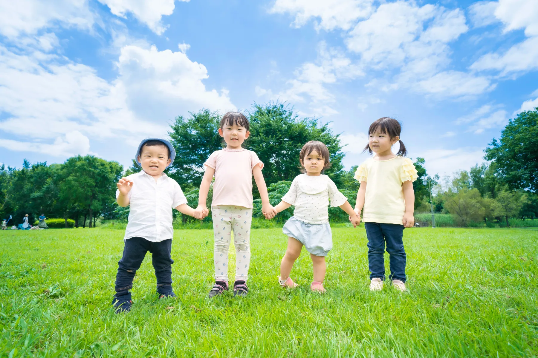 青空の下で手をつなぐ子どもたち
