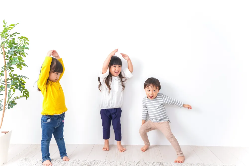 室内で一緒に体を動かす子どもたち